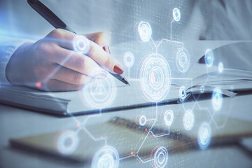 Multi exposure of hands making notes with world map hologram and data theme icons. Concept of global data.