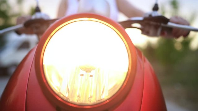 Headlight lamp of red vintage motorcycle, moped or scooter. Dolly shot.