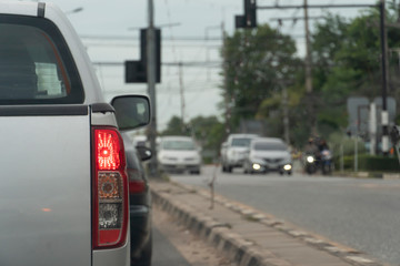 Brake cars on asphalt roads during rush hours for travel or business work. And the car parked on the opposite traffic signal.