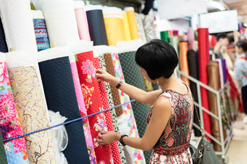 woman pick a roll of cloth at the fabric mall