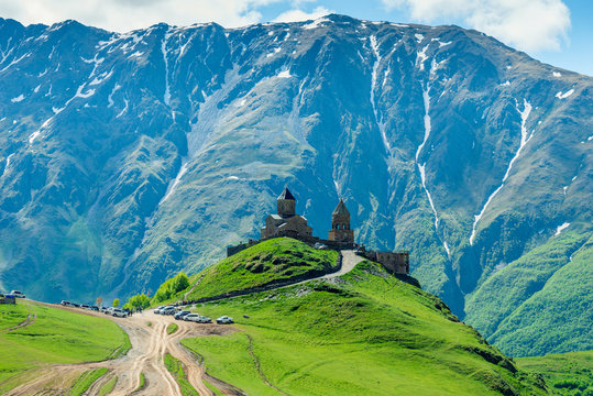 Trinity Church on the background of the picturesque high rocks with snow on the peaks, a landmark of Georgia