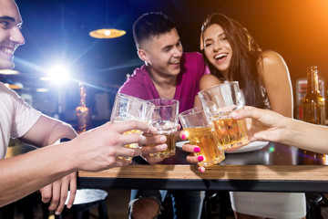 Cheerful friends in the pub. Drinking beer, talking, having fun.