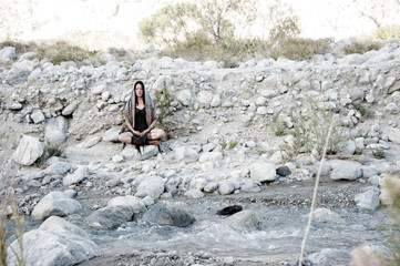 Wild Woman meditating in desert wilderness nature. 