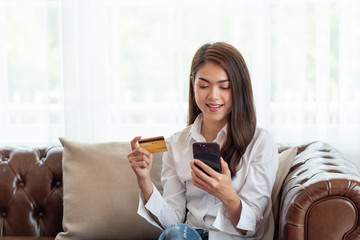 Young Asian woman holding credit card and using mobile phone, Online shopping concept