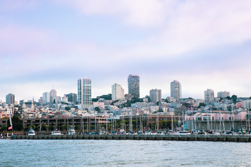 Obraz premium City of San Francisco California seen from the Bay with boats, docks, wharf and buildings of skyline in view.