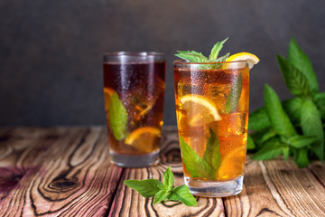 Glass of iced tea with mint and lemon. Cold drink. Rustic style