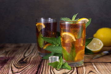 Glass of iced tea with mint and lemon. Cold drink. Rustic style