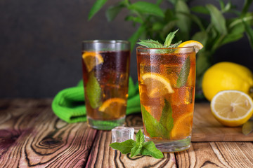 Glass of iced tea with mint and lemon. Cold drink. Rustic style