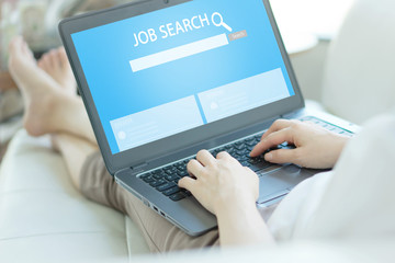 Woman trying to find work with online job search engine on laptop