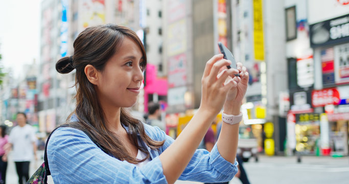 Backpacker woman visit Tokyo city, take photo on cellphone