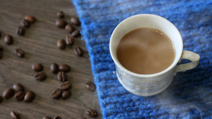 Fototapeta na wymiar Cup of coffee surrounded the warm scarf