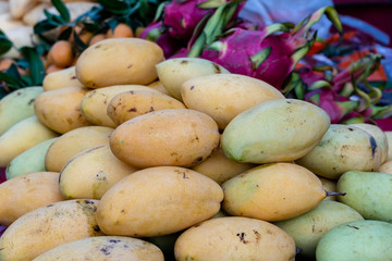 Mango, pitahaya and marian plum for sale on street market in Thailand. Tropical fruits close up