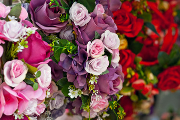 Bouquets of artificial flowers are sold at the fair. Corollas of colored small flowers. Closeup of national decorations and accessories for clothing.