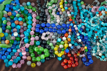 Necklace of colorful stones on the table. Many different jewelry and beads made of natural precious minerals. Stones jewelry is on sale at the fair.