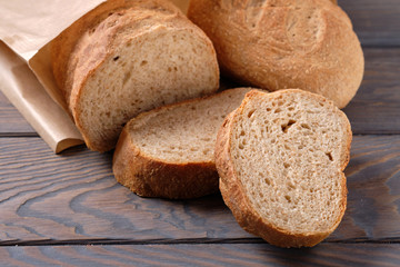 Bread and slices on wooden table
