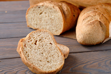 Bread and slices on wooden table