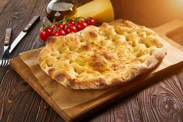 Italian focaccia bread with garlic on a rustic background