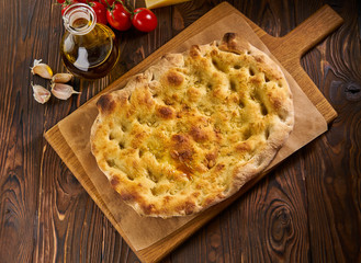 Italian focaccia bread with garlic on a rustic background