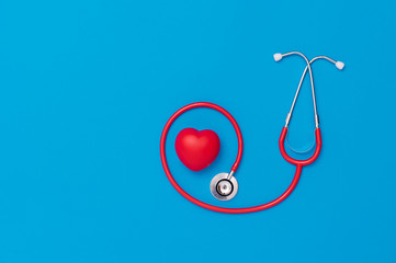 Red heart with stethoscope on blue background. Copy space. Valentines day.