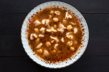 Turkish delicious traditional food Manti soup with tomato sauce, chickpea  and dry mint