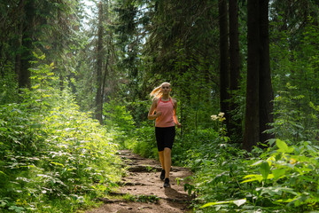 Fototapeta na wymiar young woman jogging in a mountain forest