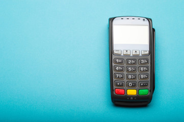 Credit card terminal on blue background. Close up of merchant  payment device, card machine.