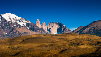 Torres del Paine National Park, its forests and summits at golden Autumn and blue sky, Patagonia,...