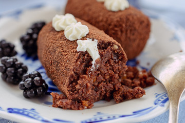 Delicious chocolate brownie as a potato form, Russian traditional dessert, on a ceramic plate, close up