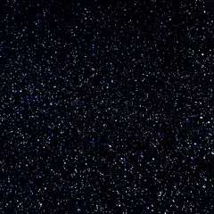 Winter night background - snowstorm against the black night sky, a lot of snowflakes