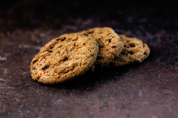 Homemade oatmeal cookies on dark vintage background.
