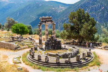 DELPHI / GREECE - JUNE 29, 2019: Beautiful scenery of Athena Pronaia temple with group of tourists in Delphi archaeological site