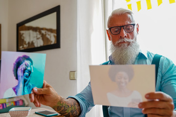Heartbroken man looking on the photos of his ex girlfriend. He is sad and depressed man. Focus the...