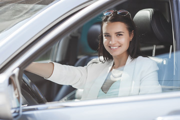Attractive young woman driving a car. Fancy woman in the automobile. Rich adult female in the car....