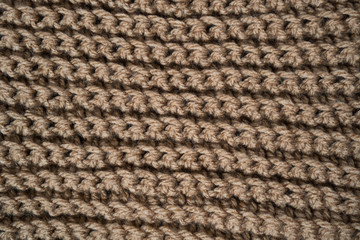 Knitted horizontal textured brown fabric on a white background. Fragment of a brown color sweater. Texture, close up. For yarn, clothing, needlework store, flyer design, banner, for site