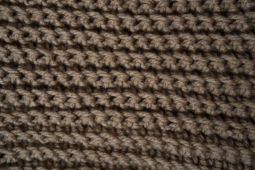 Knitted horizontal textured brown fabric on a white background. Fragment of a brown color sweater. Texture, close up. For yarn, clothing, needlework store, flyer design, banner, for site