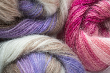 Skeins of multicolor yarn of purple, brown, pink, magenta colors. For for yarn stores, needlework, banner design.