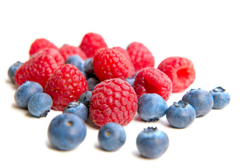 Mix berries isolated on white background. Ripe raspberry and blueberries.