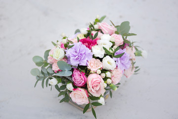 Flower arrangement in a box with spray pink roses, succulent, eustoma, white hypericum, eucaliptus.