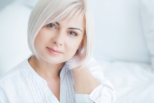 Closeup portrait of mature woman at home. Adult lady indoors. Beautiful midadult woman looking at camera.