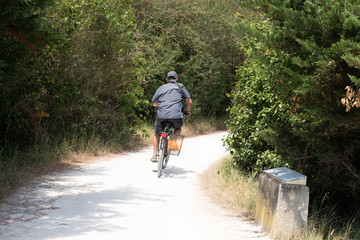 man ride bike in vacation with camera on the island of Aix Charente maritime France