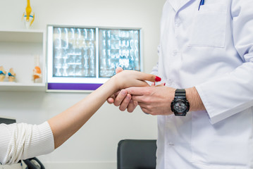 Traumatologist examining patient hands in modern hospital