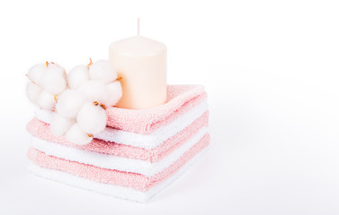 Obraz na płótnie Canvas Stack of soft towels. Spa concept. Candle and cotton flowers. Towels copy space