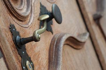 closeup of bronze handle on wooden door