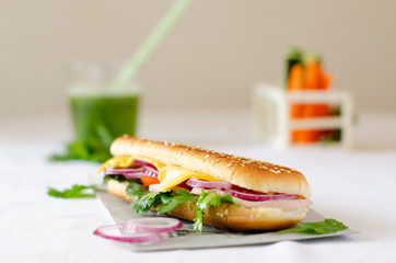 Panini on a white table with a green smoothie in the background.