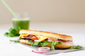 Panini on a white table with a green smoothie in the background.