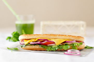 Panini on a white table with a green smoothie in the background.