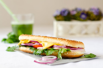 Panini on a white table with a green smoothie in the background.