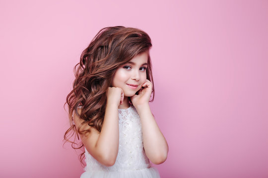 portrait of beautiful little girl in dress on pink background