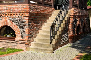 stone steps at a brick building with wrought iron railing