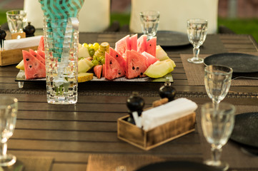 served table with fruit slices on a plate and glasses